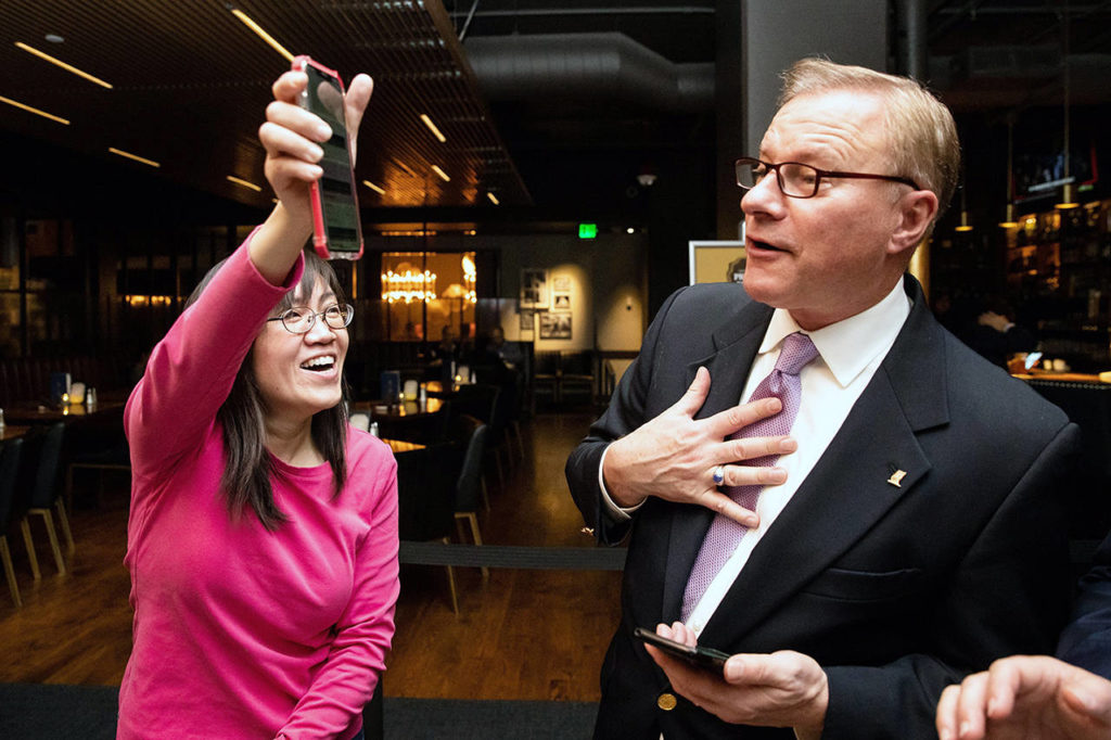 Campaign leader Linda Yates celebrates an early lead in the polls alongside KVI morning talk show host John Carlson during the anti-affirmative action group Reject Referendum 88 campaign’s election-watching event at 13 Coins in Bellevue on Tuesday. (Andy Bao/The Seattle Times via AP)
