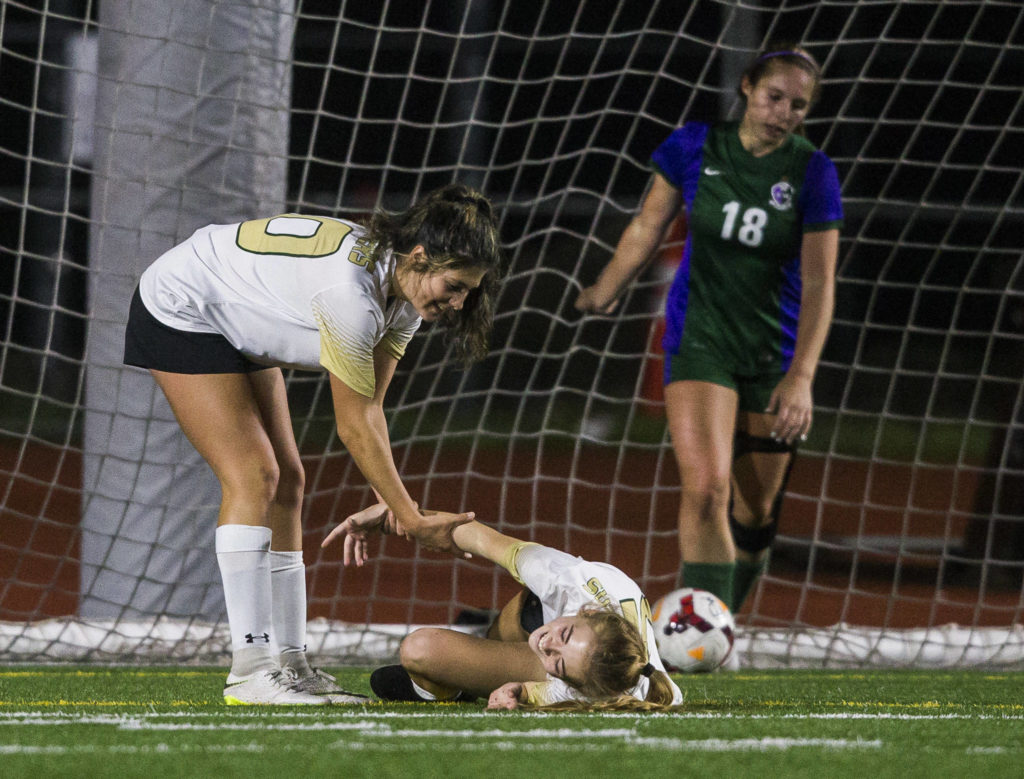 Marysville Getchell’s Alana Gomez helps Marysville Getchell’s Jadin Thompson-Sheldon up after she scores a goal during the district semifinal game on Nov. 5, 2019 in Edmonds, Wash. (Olivia Vanni / The Herald)
