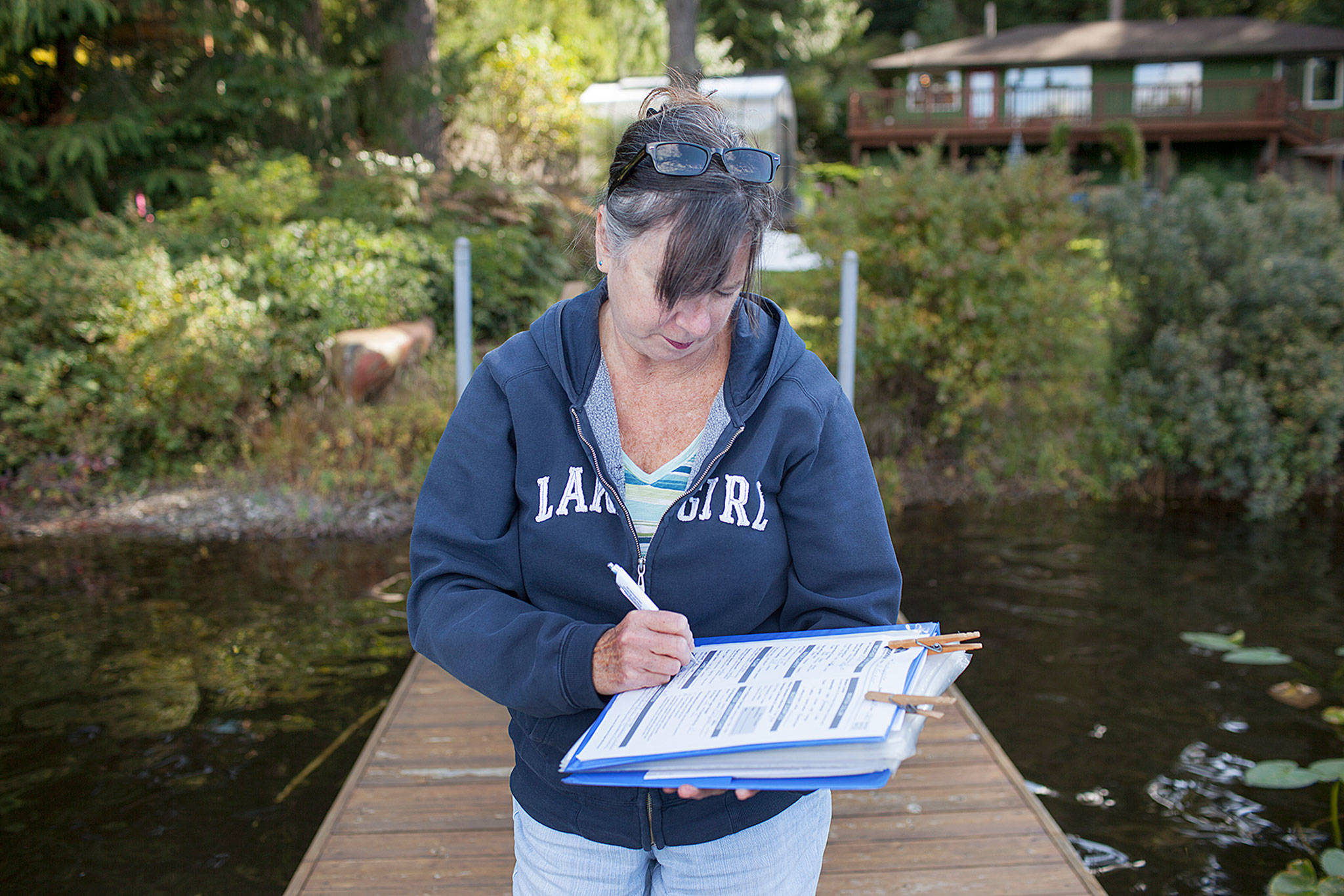 Deb Kocher records data after taking measurement on Lake Crabapple for a Snohomish County lake monitoring program. (Lizz Giordano / The Herald)
