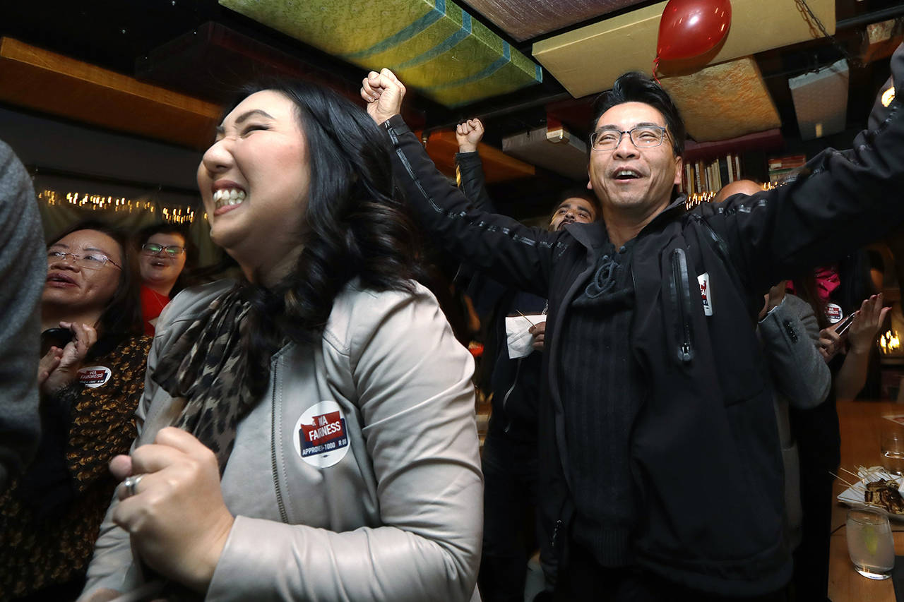 Hyeok Kim (left), a chair for WA Fairness, reacts as supporter Tony Au cheers behind as early results are posted at an election night party for supporters of Referendum 88 on Tuesday in Seattle. Voters were deciding whether one’s minority status should be considered as a contributing factor in state employment, contracting and admission to public colleges and universities. (AP Photo/Elaine Thompson)