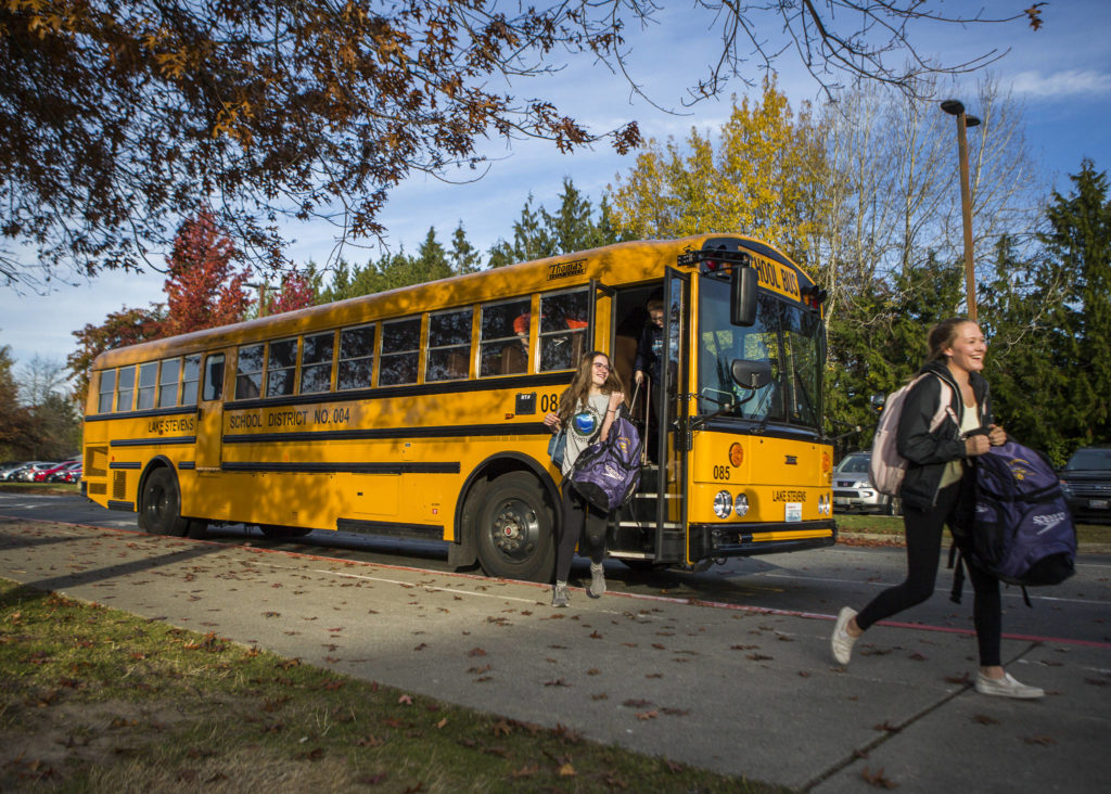 The Lake Stevens swim team gets off their bus for swim practice at Explorer Middle School on Nov. 6, 2019 in Everett, Wash. (Olivia Vanni / The Herald)
