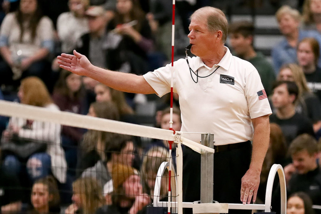 Volleyball official Pat Kaminske signals for a serve during a Wesco 3A/2A match between Oak Harbor and Arlington on Oct. 24 in Arlington. (Kevin Clark / The Herald)
