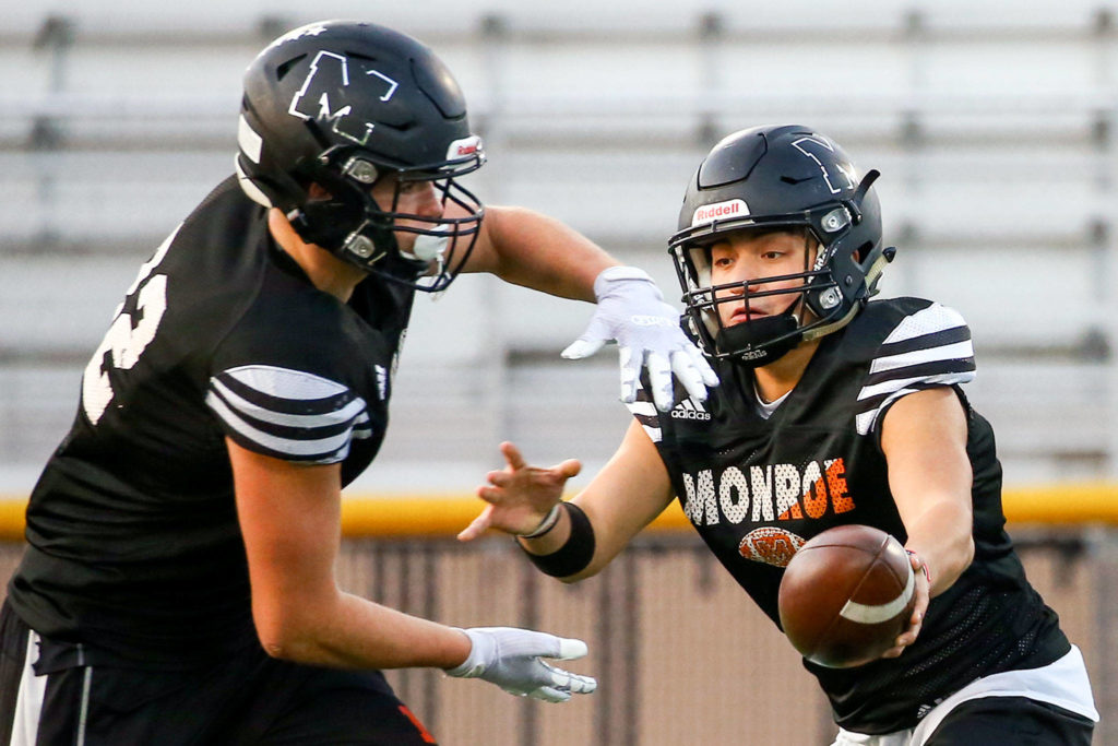 Gio Fregoso (right) hands off to Blake Rybar during practice Wednesday evening at Monroe High School on November 6, 2019.(Kevin Clark / The Herald)
