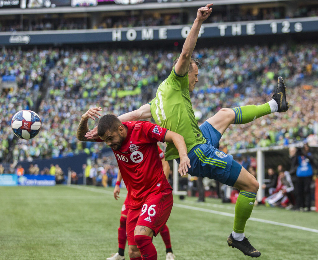 Sounders defender Brad Smith and Toronto defender Auro Jr. jump for the ball during the MLS Cup on Nov. 10, 2019 in Seattle, Wash. (Olivia Vanni / The Herald)
