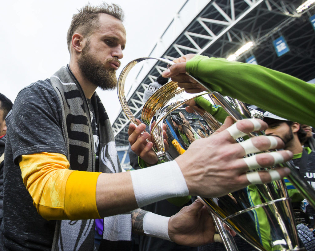 Sounders goalkeeper Stefan Frei grabs the MLS Cup after the game on Nov. 10, 2019 in Seattle, Wash. (Olivia Vanni / The Herald)

