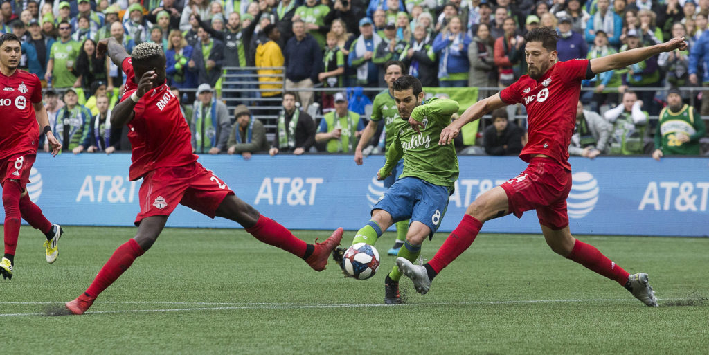 Sounders midfielder Víctor Rodríguez scores the second goal between two Toronto defenders as the Seattle Sounders beat Toronto FC 3-1 to win the MLS Cup at CenturyLink Field on Sunday, Nov. 10, 2019 in Seattle, Wash. (Andy Bronson / The Herald)
