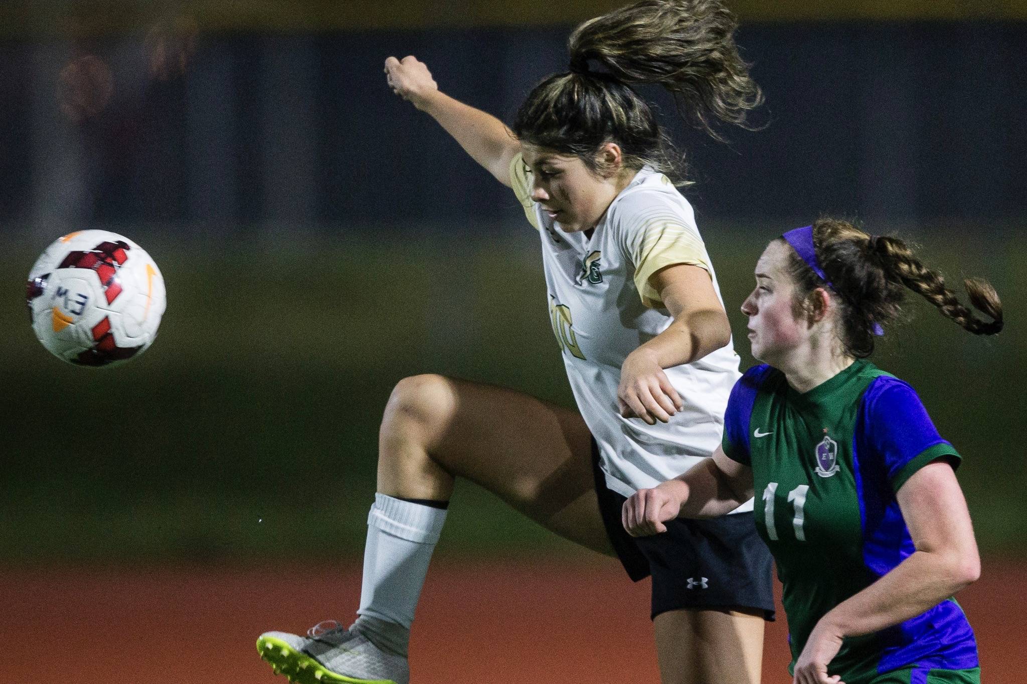 Marysville Getchell’s Alana Gomez (left) battles Edmonds-Woodway’s Sydney Chappell for the ball during the Chargers’ state-clinching win last week. Marysville Getchell is one of six local prep girls soccer teams headed to their respective state tournaments. (Olivia Vanni / The Herald)
