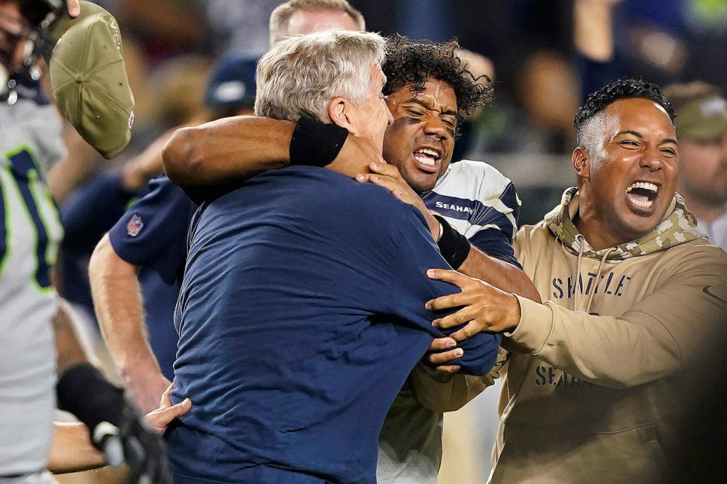 Seattle coach Pete Carroll (left) celebrates with quarterback Russell Wilson (center) after the Seahawks defeated San Francisco, 27-24 in overtime, on Monday in Santa Clara, California. (AP Photo/Tony Avelar)
