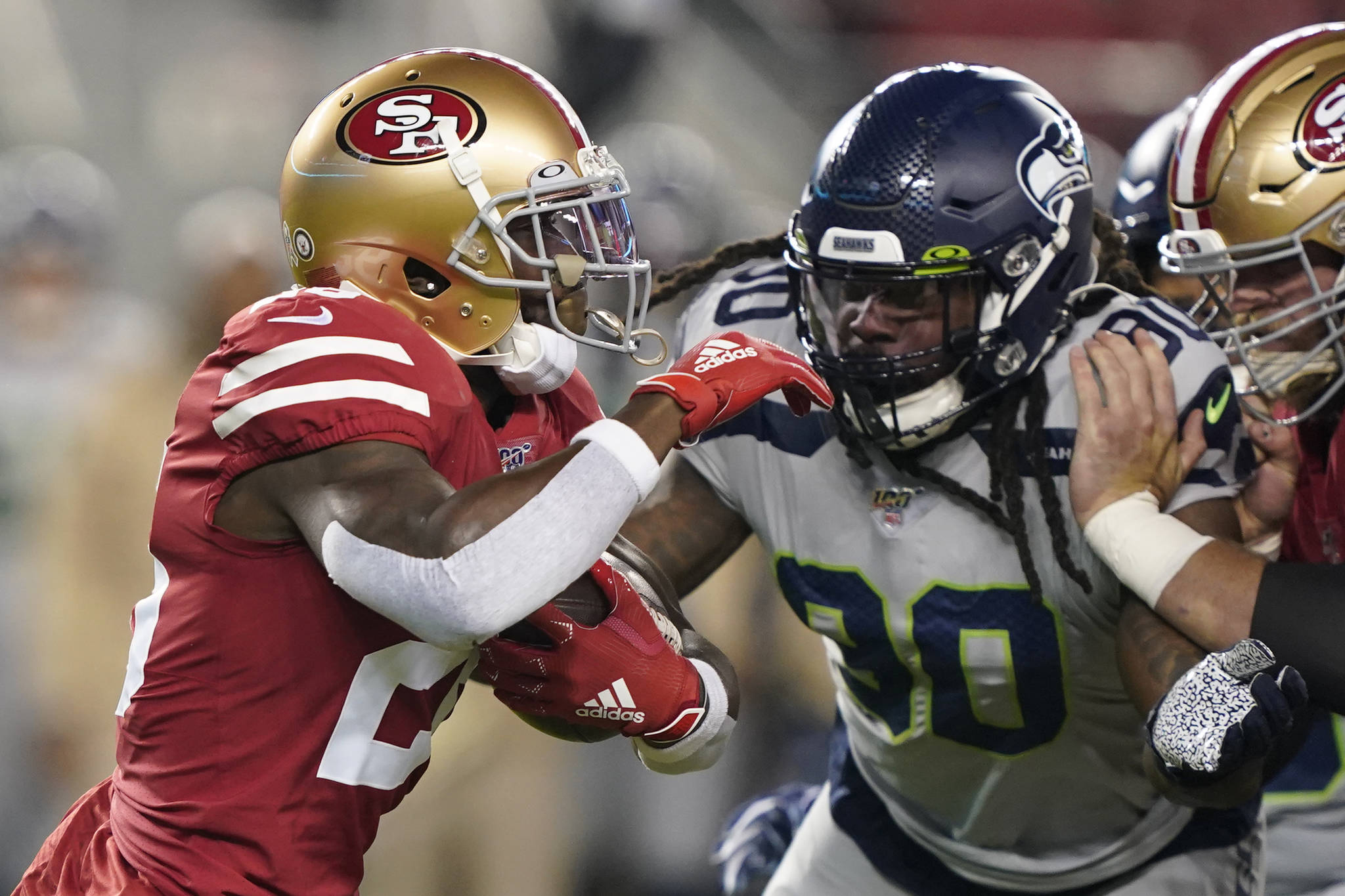 Seattle Seahawks defensive end Jadeveon Clowney (right) chases down San Francisco 49ers running back Tevin Coleman during Monday nights’ game. (AP Photo/Tony Avelar)