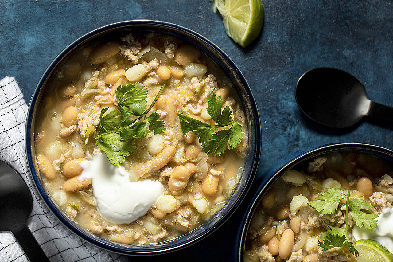 Pork chili verde is a tomato-less white and green number made with fresh poblano and jalapeno peppers, white beans, large white corn kernels (hominy) and ground pork. (Photo by Justin Tsucalas for the Washington Post)