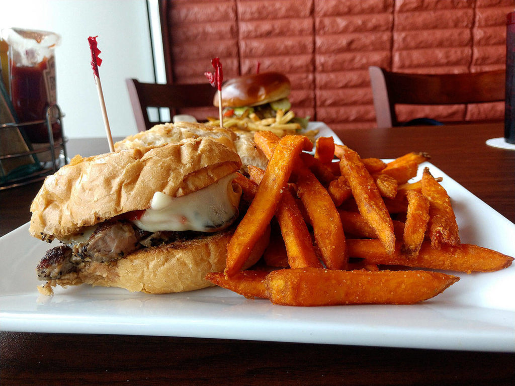 Centennial’s steak sandwich features sliced marinated flank steak, unions, mushrooms, peppers and Swiss cheese on a French roll. Upgrade your side option to sweet potato fries for 99 cents. (Sara Bruestle/The Herald)
