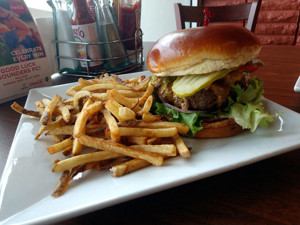 Centennial Bar & Grill’s cheeseburger is topped with your choice of cheese, lettuce, tomato, red onion, pickles and the house aioli, and served with hand cut fries. (Sara Bruestle/The Herald)
