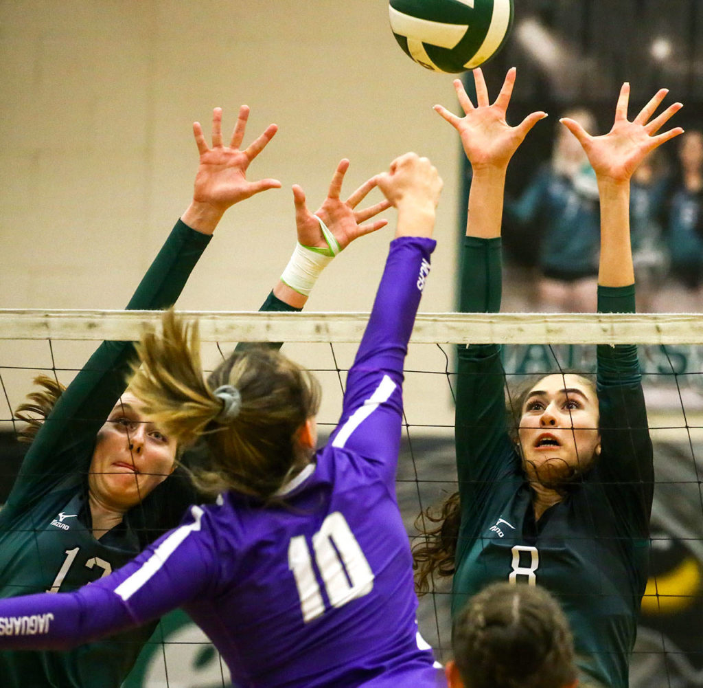 Jackson’s Ainsley Johanson (left) and Erin Ingram attempt a block on North Creek’s Allison Wilks. (Kevin Clark / The Herald)
