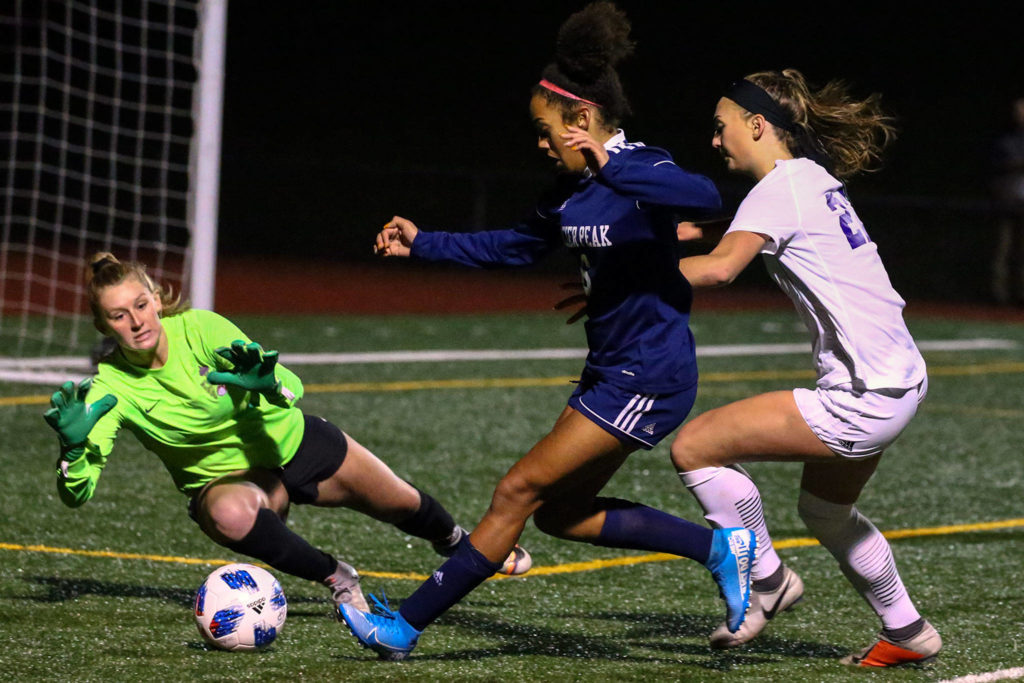 Sumner goalkeeper McAllister Smith (left) stops a run at goal by Glacier Peak’s Aaliyah Collins (middle) during a 4A state playoff game on Wednesday at Glacier Peak High School in Snohomish. Sumner won 2-1. (Kevin Clark / The Herald)
