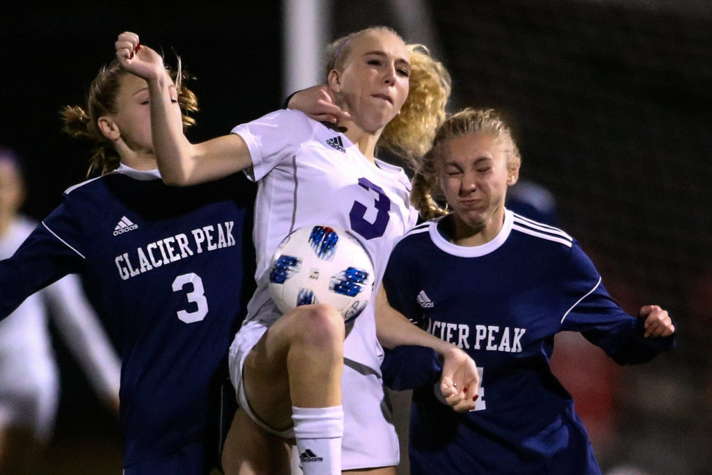 Glacier Peak’s Chloe Seelhoff (right) and Annika Lambott (right) fight with Sumner’s Madison Morgan for control Wednesday evening at Glacier Peak High School in Snohomish on November 13, 2019. Sumner won 2-1. (Kevin Clark / The Herald)
