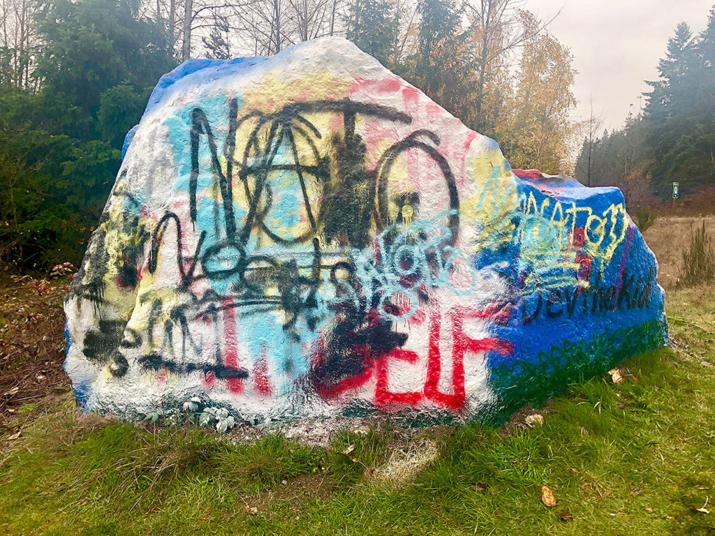 This week, the Epstein slogan on the Snohomish rock was tagged over with NATO graffiti using the anarchy sign for the letter A. (Andrea Brown / The Herald)
