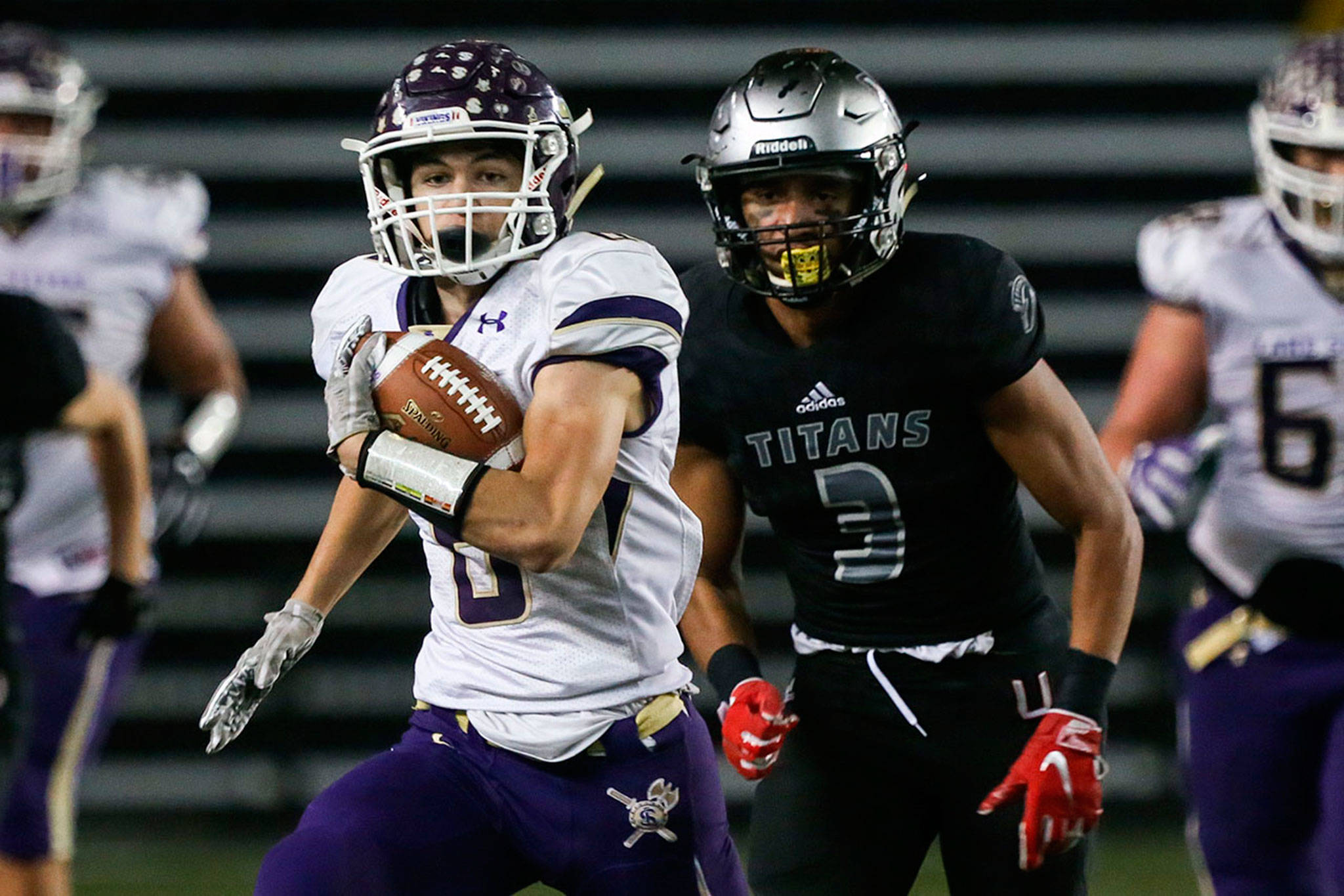 Lake Stevens running back Dallas Landeros carries the ball with Union’s Darien Chase trailing during last season’s 4A state championship game at the Tacoma Dome. (Kevin Clark / The Herald)