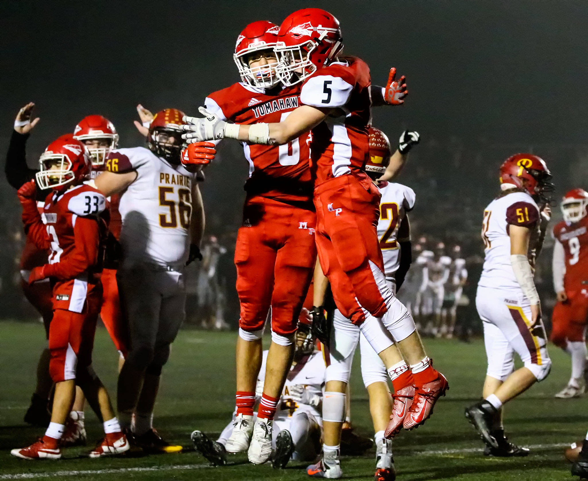 Marysville Pilchuck’s Dillon Kuk (left) and Dylan Carson celebrate after the latter’s go-ahead touchdown run in overtime during Friday night’s Class 3A first-round state-playoff game at Quil Ceda Stadium in Marysville. The Tomahawks beat Prairie 37-30 in overtime to advance to the state quarterfinals. (Kevin Clark / The Herald)