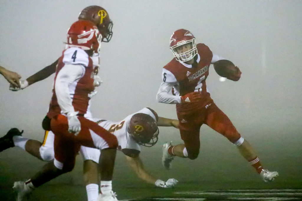 Marysville Pilchuck’s Dillon Kuk rushes through a thick fog that blanketed the field for much of the game. (Kevin Clark / The Herald)
