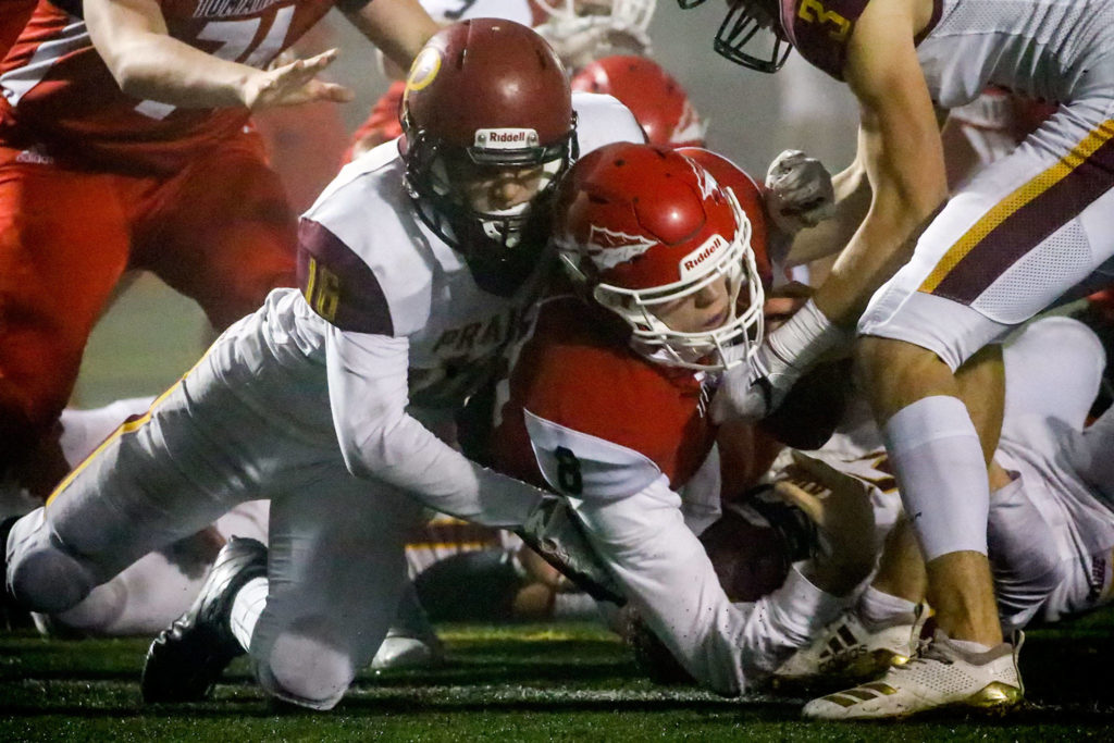 Marysville Pilchuck’s Jake Elwood falls across the goal line for a touchdown with Prairie’s Nickolas Lawhead tackling Friday evening at Quil Ceda Stadium in Marysville on November 15, 2019. Marysville Pilchuck won 37-30 in overtime. (Kevin Clark / The Herald)
