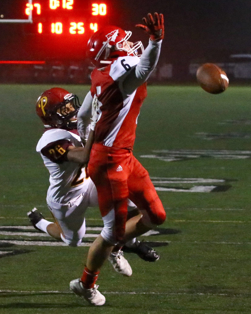 Marysville Pilchuck’s Dillon Kuk reaches for a pass with Prairie’s Dion Garrett committing a pass inference Friday evening at Quil Ceda Stadium in Marysville on November 15, 2019. Marysville Pilchuck won 37-30 in overtime. (Kevin Clark / The Herald)
