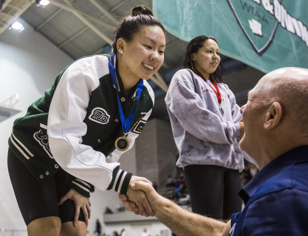 Jackson’s Mia Chang receives her first place medal for the 200 yard IM during the 2019 4A Girls State Swim and Dive Championship on Nov. 16, 2019 in Federal Way, Wash. (Olivia Vanni / The Herald)
