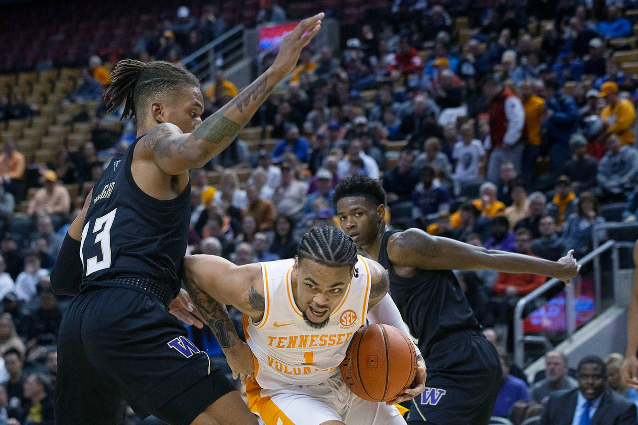 Tennessee’s Lamonte Turner (center) drives past Washington’s Hameir Wright (left) during the first half of a game in the James Naismith Classic on Saturday in Toronto. (Chris Young/The Canadian Press via AP)