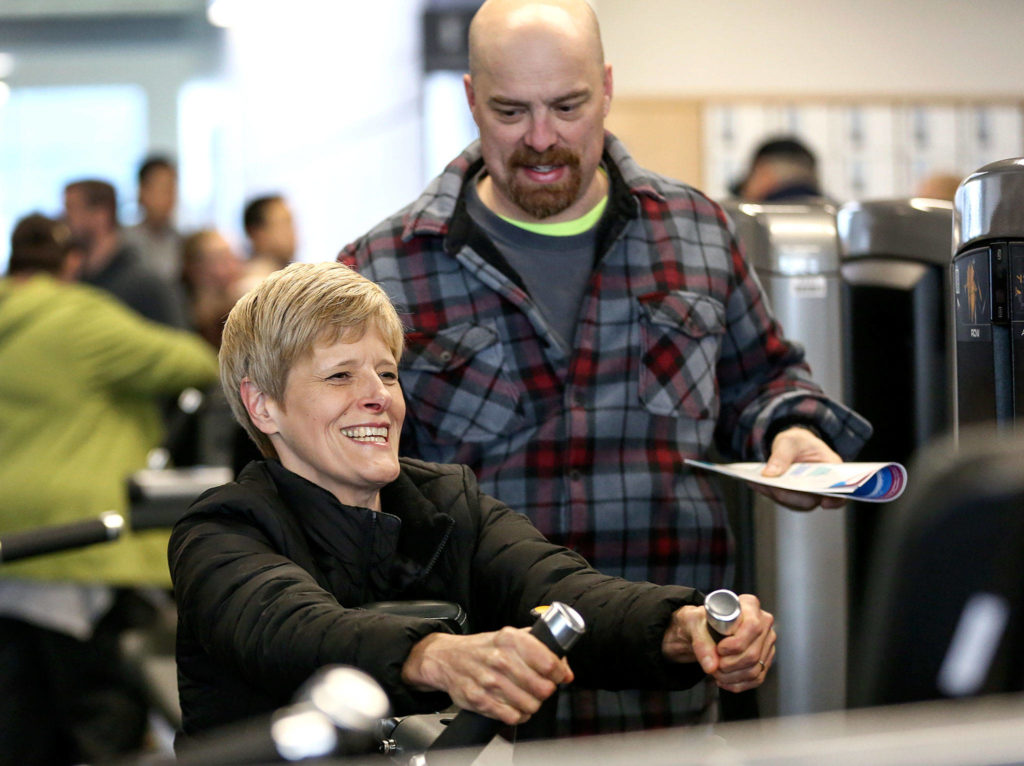 Diane Zaugg tries out exercise equipment with husband Reid Zaugg in the soon-to-be opened Everett YMCA. (Kevin Clark / The Herald)
