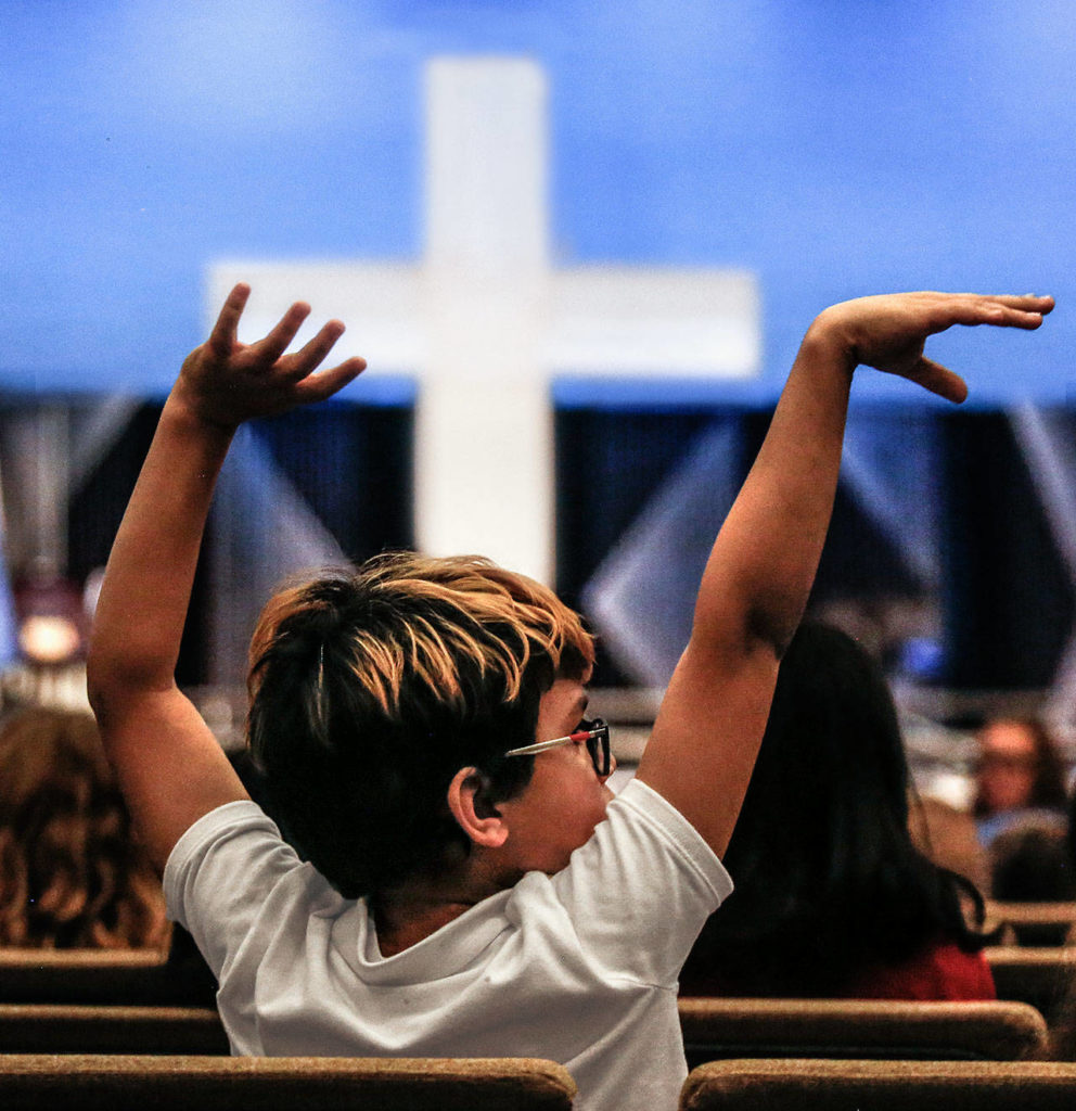 Braylon McMillen, a fifth-grader at Northshore Christian Academy, moves to the music of the jazz band Wednesday during a celebration of his school being recognized as a National Blue Ribbon School for 2019. The event included music, speeches and prayer. (Dan Bates / The Herald)
