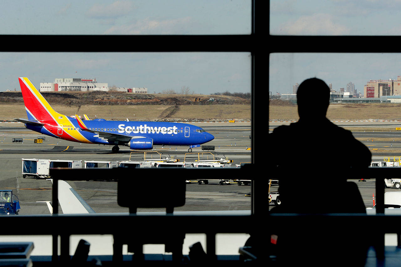 A Southwest Airlines jet moves on the runway as a person eats at a terminal restaurant at LaGuardia Airport in New York on Jan. 25. The National Transportation Safety Board met Tuesday in Washington to consider the cause of a deadly engine failure on a Southwest Airlines flight last year. The incident killed a passenger who was blown partly out of the plane when a piece of the engine shattered the window next to her. (AP Photo/Julio Cortez, File)