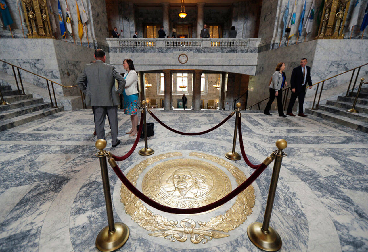 The Washington state seal is protected by ropes in the rotunda of the Legislative Building in late April, at the Capitol in Olympia, at the start of the last week of the Legislature’s regular session. (Ted S. Warren / Associated Press file photo)