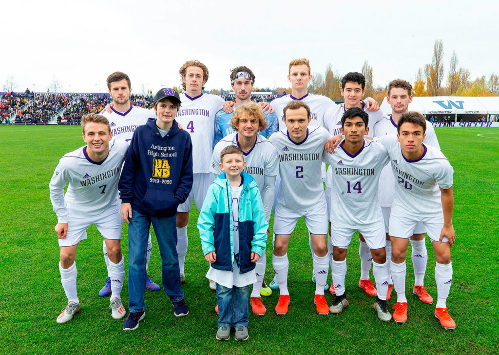 Arlington’s Trevor Glassman, 14, (dark sweatshirt) poses with members of the University of Washington soccer team and honorary captain Jace Anderson prior to a recent game. (University of Washington photo)
