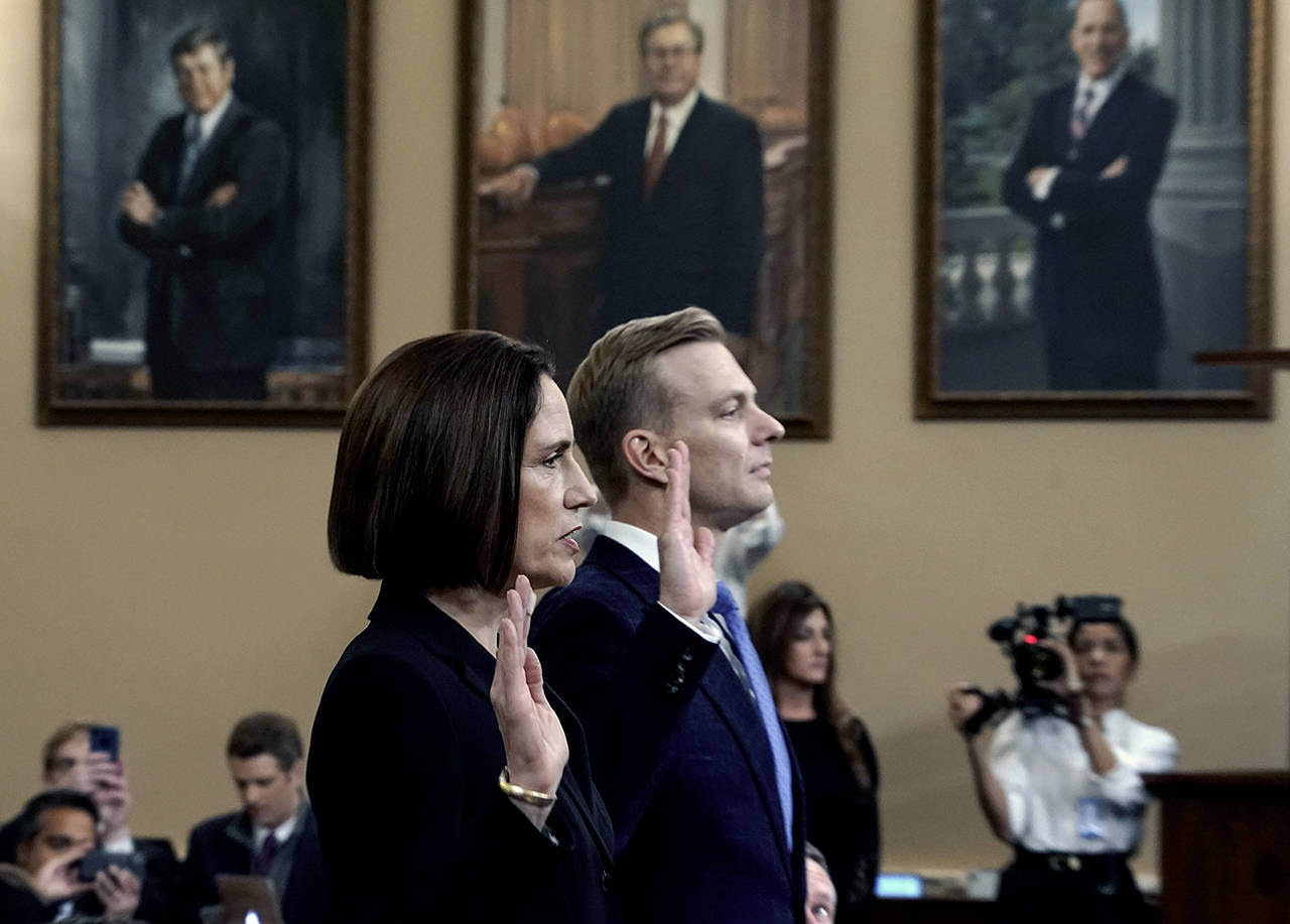 Former White House national security aide Fiona Hill (left) and David Holmes, a U.S. diplomat in Ukraine, are sworn in to testify before the House Intelligence Committee on Capitol Hill in Washington on Thursday, during a public impeachment hearing of President Donald Trump’s efforts to tie U.S. aid for Ukraine to investigations of his political opponents. (AP Photo/J. Scott Applewhite)