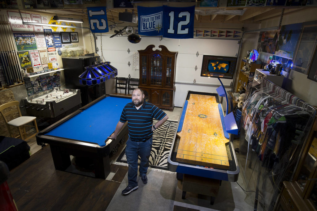 Josh Whall in his gaming room, the garage, at his home on Nov. 22 in Marysville. The room has shuffleboard, hockey table and a pool table, and even a collection of the patches from each of the MLB’s All-Star games. (Andy Bronson / The Herald)

