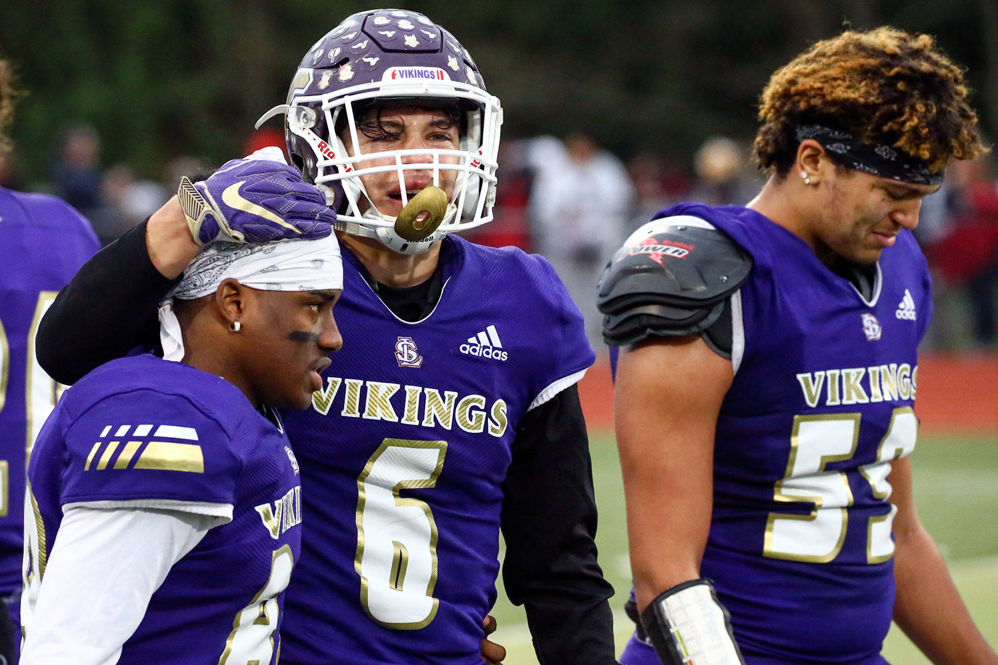 Lake Stevens players Camdyn Hanks (left-right), Dallas Landeros and Nick Wiskow-Holmes walk off the field dejected after their title dreams ended with a 24-22 loss to Mount Si in a Class 4A state quarterfinal Saturday afternoon at Lake Stevens High School. (Kevin Clark / The Herald)