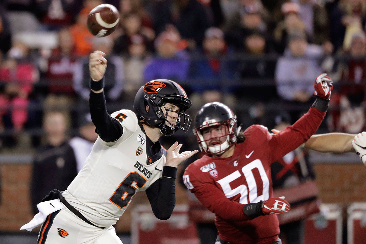 Oregon State quarterback Jake Luton (6) passes under pressure from Washington State defensive lineman Karson Block (50) during the first half of an NCAA college football game Saturday, Nov. 23, 2019, in Pullman, Wash. (AP Photo/Ted S. Warren)