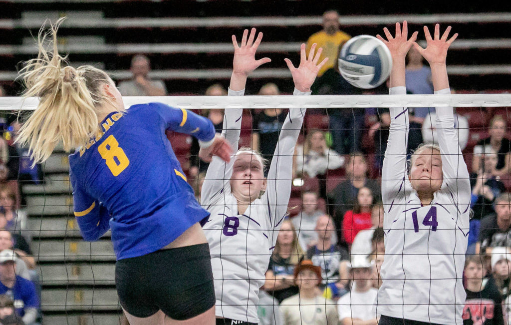 Tahoma’s Chey Jones (8) spikes through Lake Stevens’ Michelle Fast (8), and Maddie Iseminger (14) during the 4A state volleyball championship match on Nov. 23, 2019, at the Yakima Valley SunDome. (TJ Mullinax / for The Herald)

