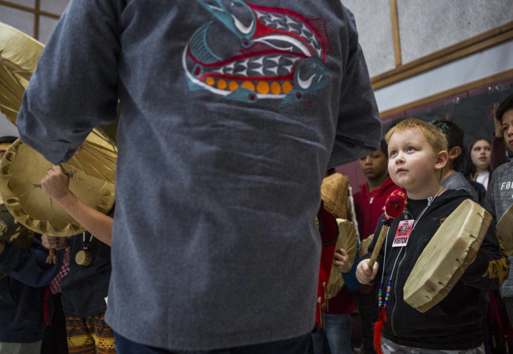 Daniel T. Williams III looks up at an older drummer while he drums during Tulalip Day at Quil Ceda Tulalip Elementary on Wednesday in Tulalip. (Olivia Vanni / The Herald)
