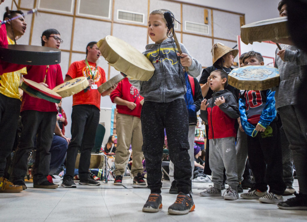 Kyle Bontrager, center, sticks his tongue out in concentration while he drums during Tulalip Day at Quil Ceda Tulalip Elementary on Wednesday in Tulalip. (Olivia Vanni / The Herald)

