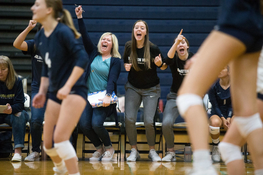 Arlington head coach Whitney Williams, left, cheers with player Reese Talbot, center, after the Eagles scored a point against Shorecrest Sept. 17 at Arlington High School. (Andy Bronson / The Herald)
