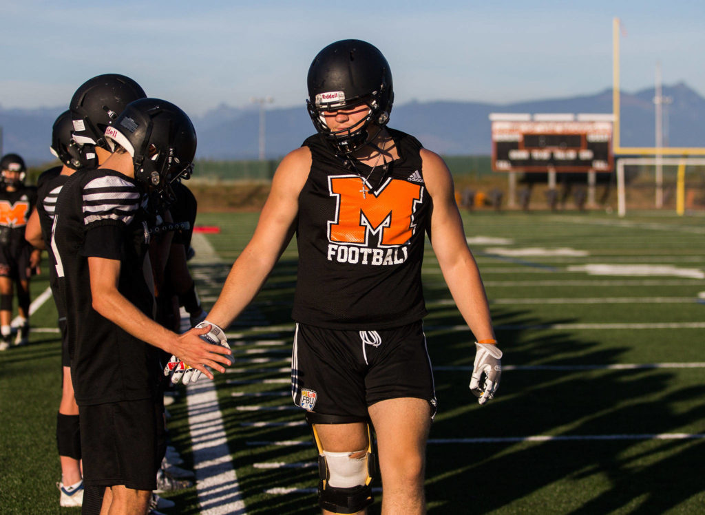 Gavin Monroe high-fives his teammates during football practice at Monroe High School on Wednesday, Aug. 28, 2019 in Monroe, Wash. (Olivia Vanni / The Herald)
