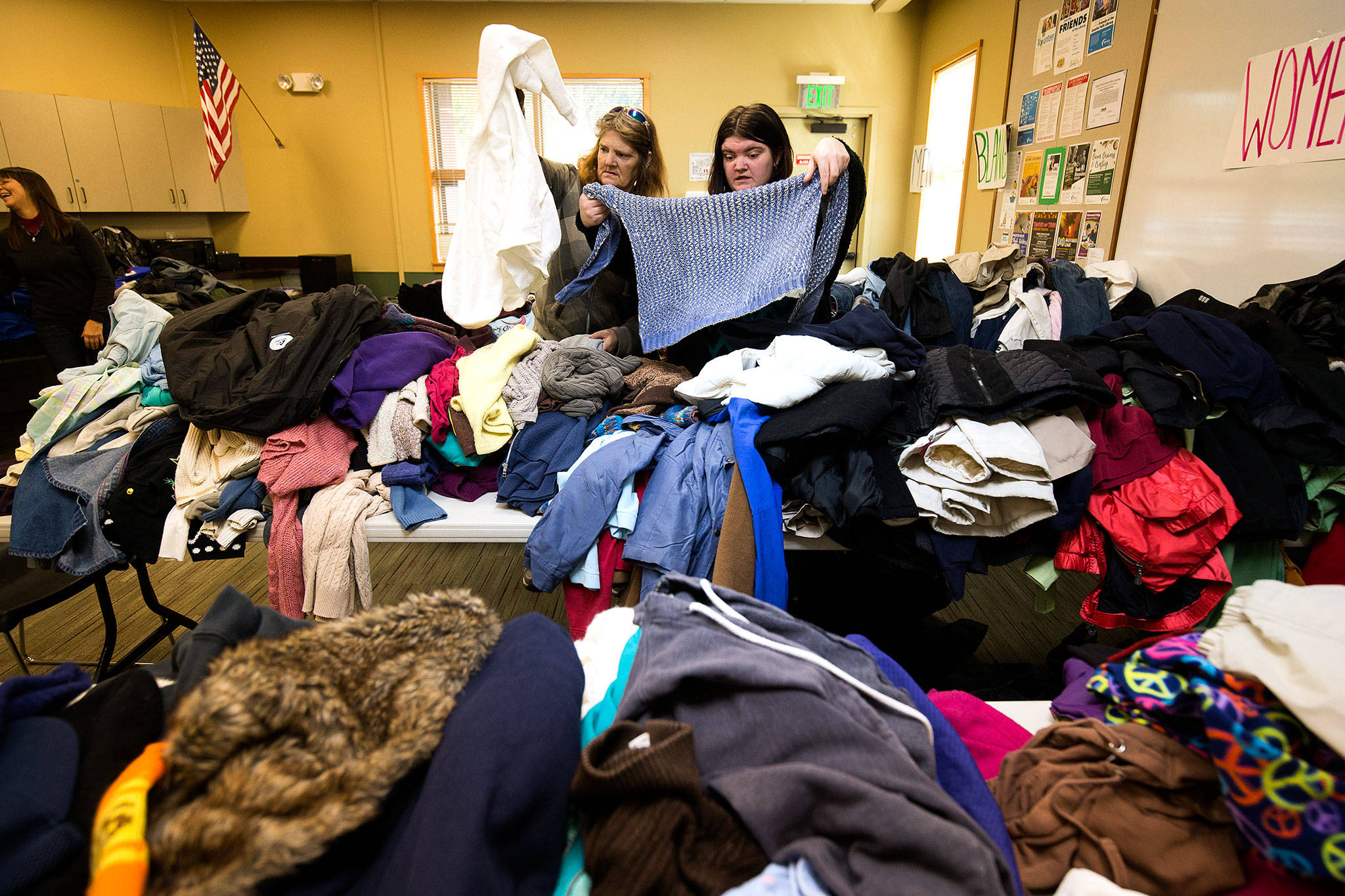 Nancy Schlund, left, helps pick out clothes with her daughter Katie at the Winter Clothes Giveaway by the Angel Resource Connection in the Granite Falls Library. (Andy Bronson / The Herald)