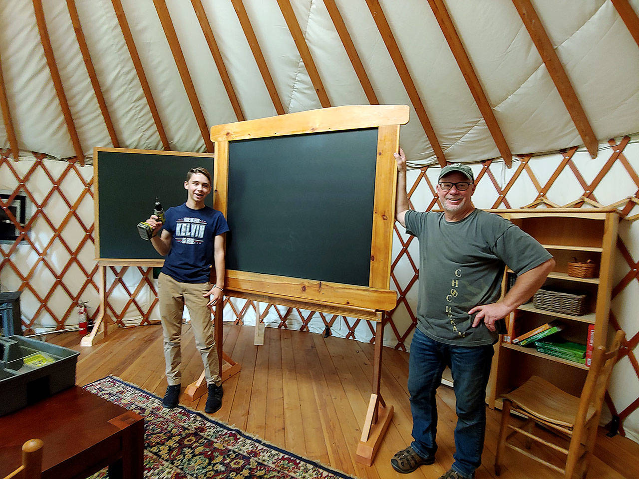 Woodhaven Faculty Liaison Kent Ratekin and freshman Kelvin Jenkins put together a chalkboard at the Organic Farm School classroom. (Marli Jenkins)