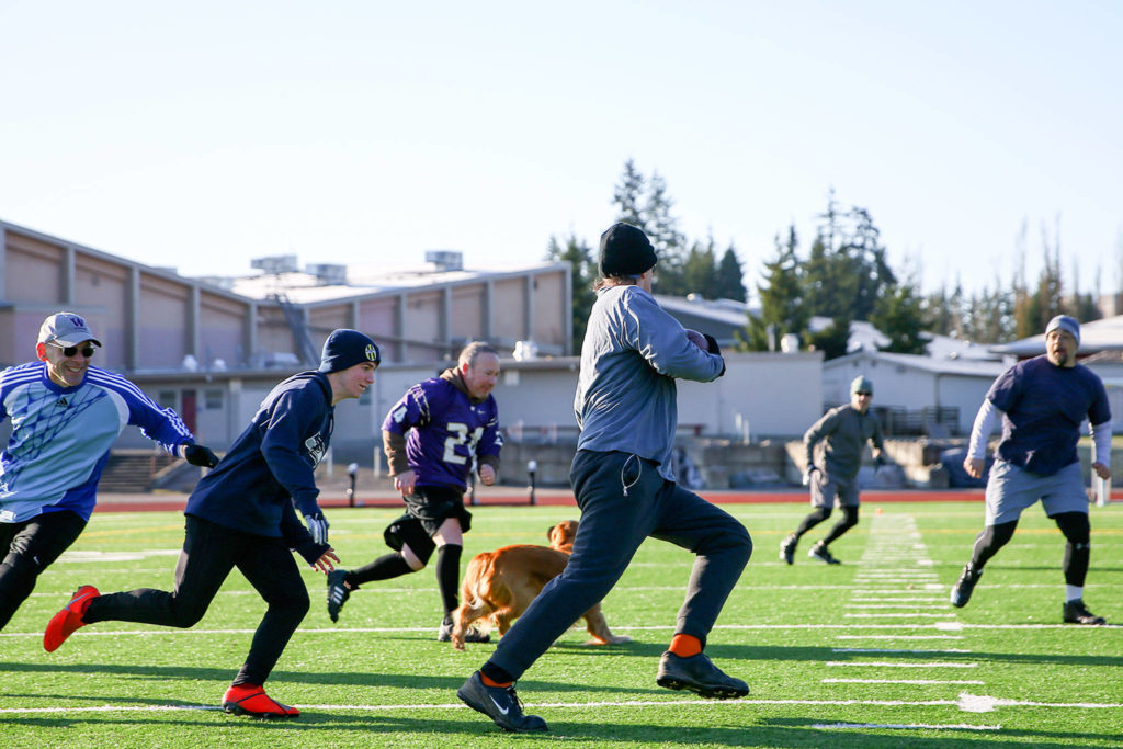 Friends from high school, now in their 50s, play in an annual post-Thanksgiving touch football game Saturday morning at Cascade High School in Everett. (Kevin Clark / The Herald)
