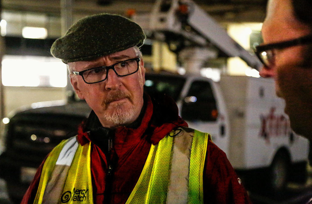 Dennis Kelly, a Catholic deacon (left), talks with Dr. Jimmy Grierson, a MercyWatch volunteer. (Dan Bates / The Herald)
