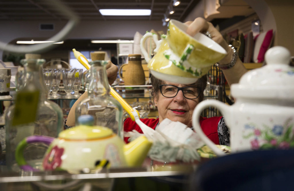 Volunteer Judi Drake dusts around teapots at the Assistance League of Everett on Nov. 18. The gruop sell items at their thrift store and donates the proceeds to Snohomish County families. All 300 people who help out are volunteers. (Andy Bronson / The Herald)
