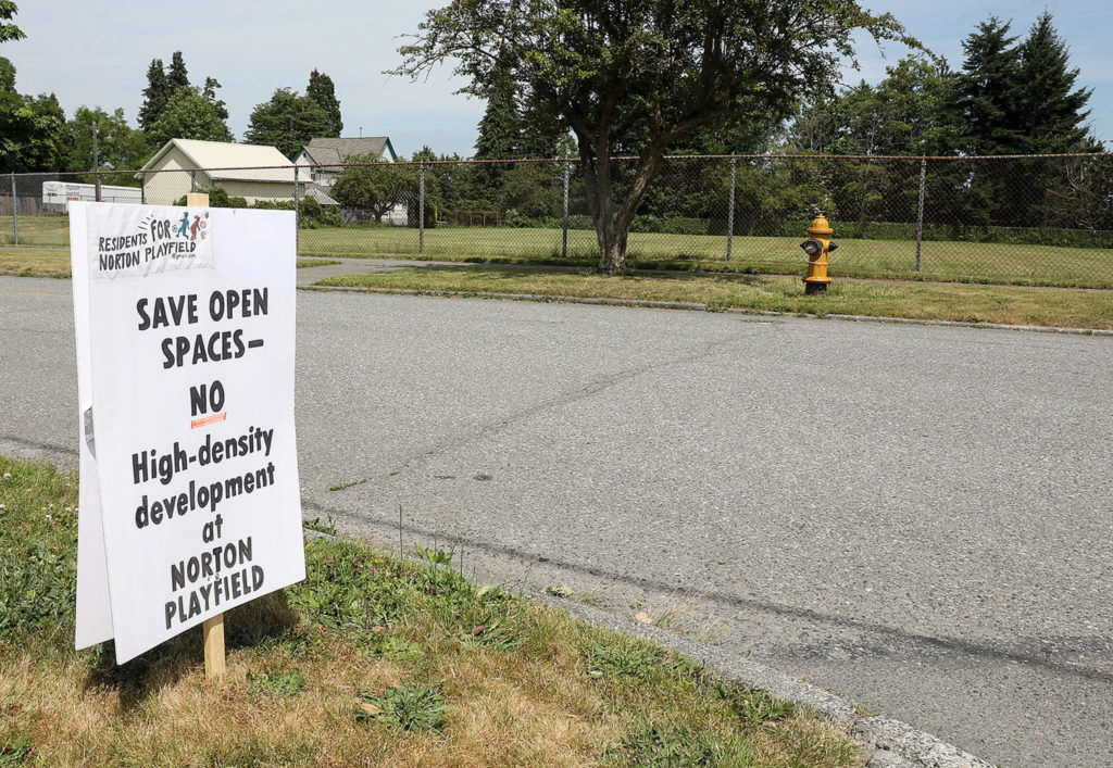 Signs touting opposition to a proposal by the Everett School District and Housing Hope to build affordable housing for children and families on a playfield on Norton Avenue popped up in the Port Gardner neighborhood earlier this year. (Lizz Giordano / The Herald)
