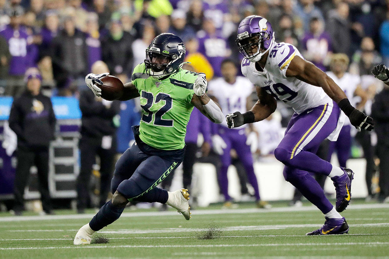 Seattle Seahawks’ Chris Carson cuts upfield ahead of Minnesota’s Danielle Hunter during the Seahawks’ 37-30 win over the Vikings on Monday at CenturyLink Field in Seattle. (AP Photo/Ted S. Warren)