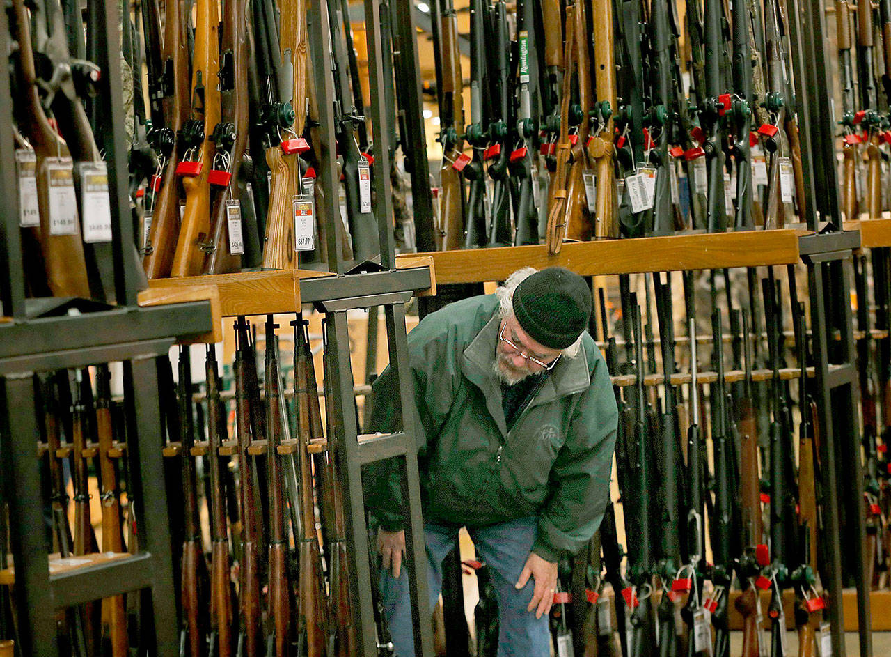 A man looks at the shotgun section of Cabela’s while shopping on Black Friday in Hazelwood, Missouri. The number of background checks conducted by federal authorities is on pace to break a record by the end of this year. (Christian Gooden/St. Louis Post-Dispatch via AP)