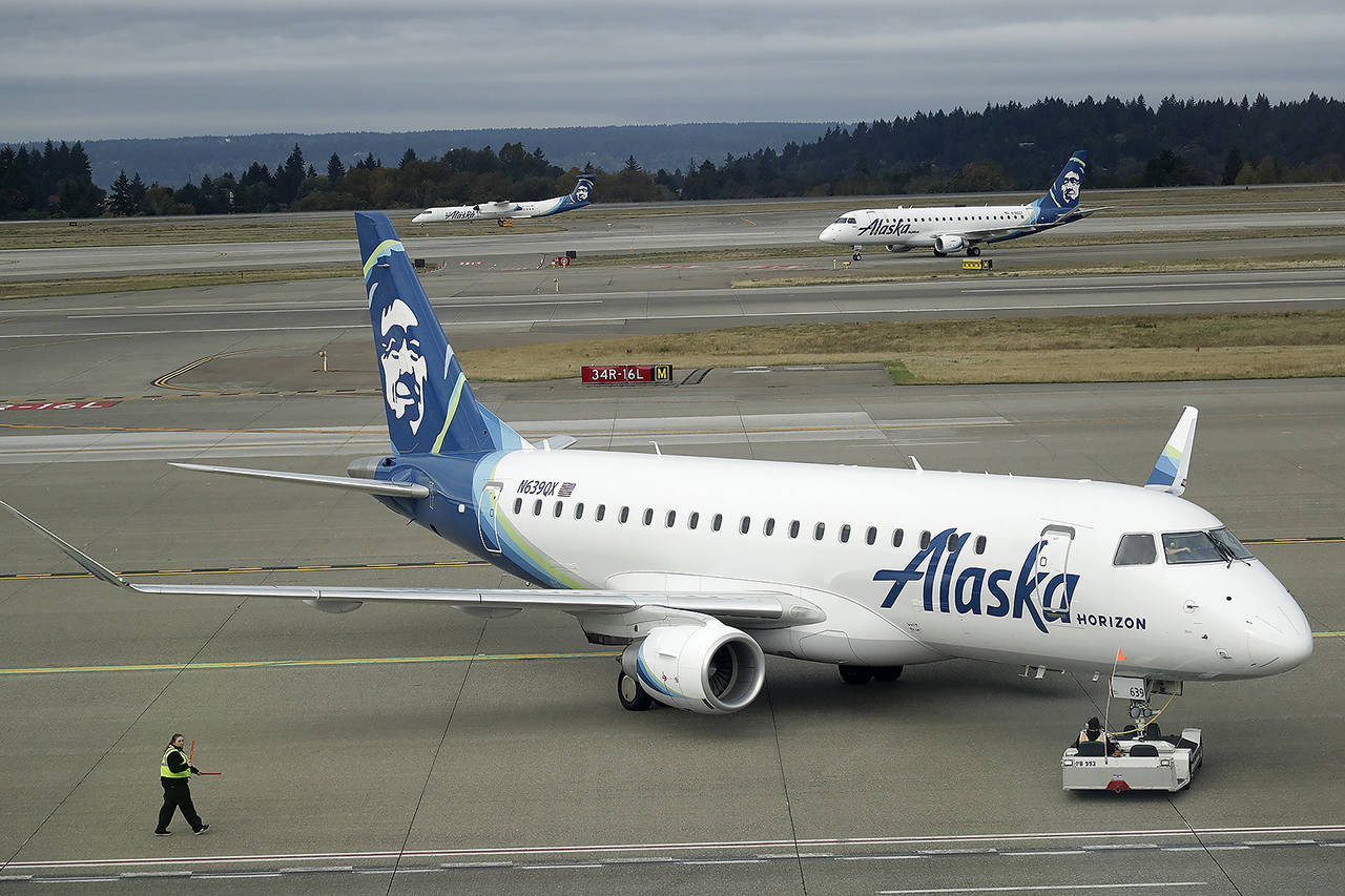 A passenger plane with Horizon Air, a regional airline based in SeaTac, that is a sister carrier with Alaska Airlines, is pushed out for taxi Oct. 7 at Seattle-Tacoma International Airport in Seattle. (AP Photo/Ted S. Warren)